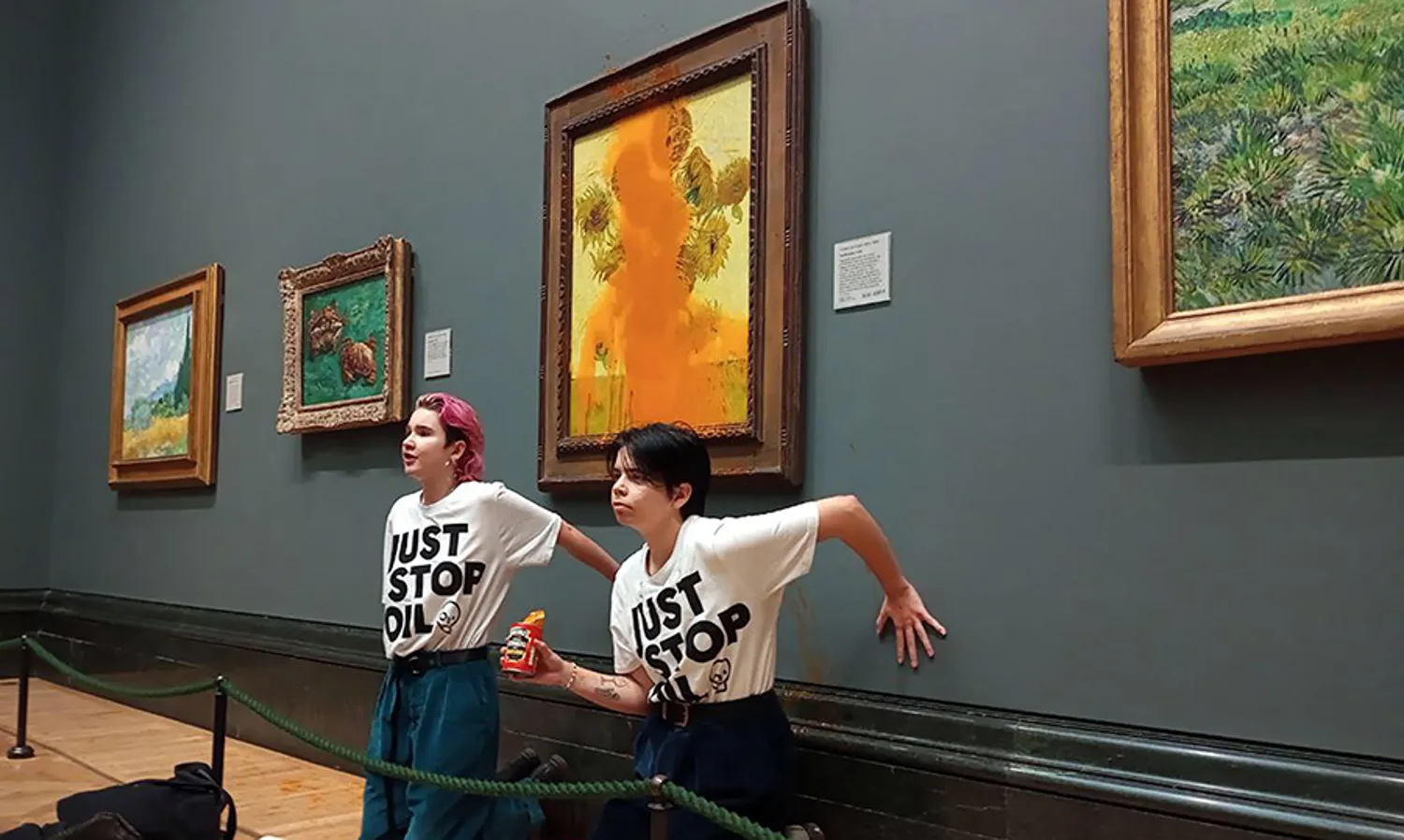 Activists from Just Stop Oil climate campaign group threw tomato soup on Vincent van Gogh's "Sunflowers" and glued their hands to the wall beneath the painting at the National Gallery in London on Oct. 14. They were arrested and charged with criminal damage and aggravated trespass. HANDOUT PHOTO, JUST STOP OIL/AFP VIA GETTY IMAGES